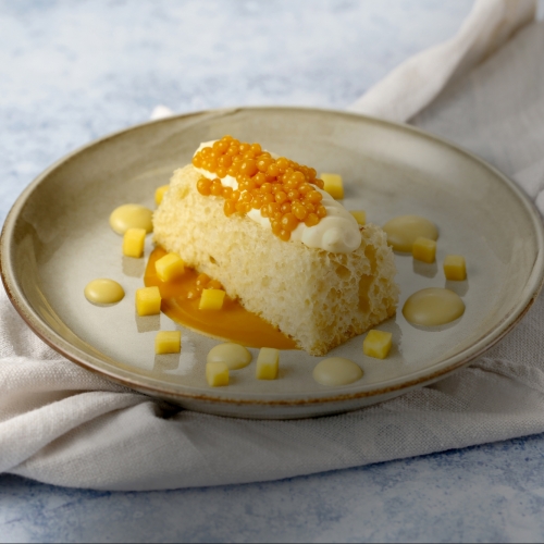 Mango sponge with clotted custard, served with a passion fruit emulsion and mango caviar